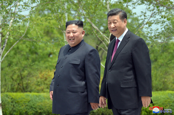 Chinese President Xi Jinping, right, and North Korean leader Kim Jong-un take a stroll at the Kumsusan State Guesthouse in Pyongyang on June 21, 2019, in a photo released by the North's official Korean Central News Agency.  