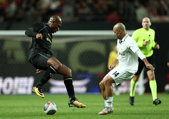 FC Spear's Didier Drogba, left, vies for the ball with Shield United's Javier Mascherano during the Nexon Icons Match against FC Spear at Seoul World Cup Stadium in western Seoul on Sunday. [YONHAP] 