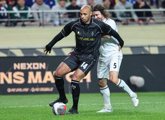 Thierry Henry dribbles around Carles Puyol