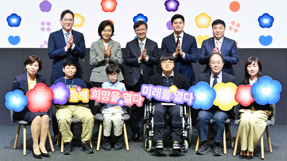 Second row, from left: Samsung Electronics Executive Chairman Lee Jae-yong, former Leeum Museum of Art Director Hong Ra-hee, Seoul National University Hospital (SNUH) President Kim Young-tae, People Power Party lawmaker Kim Yong-tae, SNUH Vice Director Park Joong-shin and Vice Director of Pediatrics at SNUH Choi Eun-hwa, front row, far left, pose with event participants, including children who received support from the Child Cancer and Rare Disease Project, which was launched with a donation from late Samsung Chairman Lee Kun-hee, at SNUH's Children's Hospital in Jongno District, central Seoul, on Monday. [SAMSUNG ELECTRONICS] 