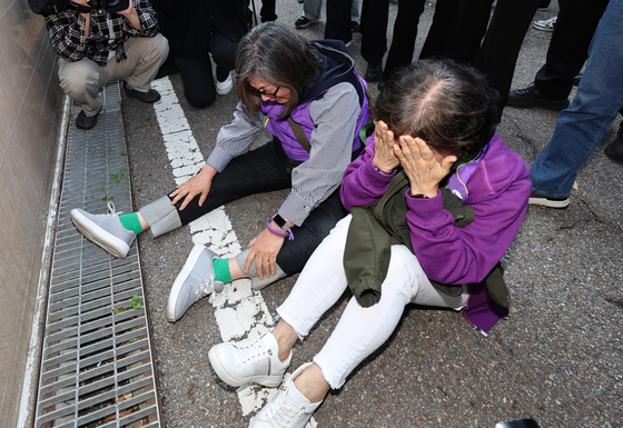 Bereaved relatives of the Itaewon crowd crush cry in front of the Seoul Western District Court in Mapo District, western Seoul, on Thursday after the court found the ex-chief of the Seoul Metropolitan Police Agency not guilty. [NEWS1]