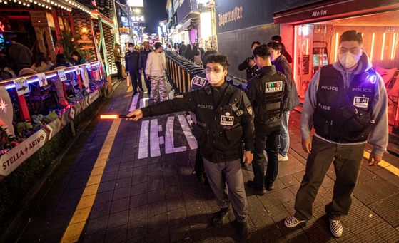 Police stationed in Itaewon ordered people to move along the once-popular alleyway on Oct. 27, 2023. A barrier had been set up to prevent overcrowding, believed to have been a significant factor in the deaths of 159 people in a crowd crush two years ago. [CHOI KI-WOONG]