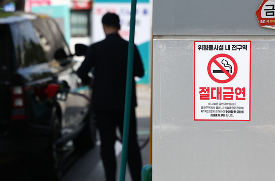 A sign warning against smoking was displayed at a gas station in downtown Seoul on July 30. Under the revised regulation that took effect in August, individuals caught smoking in areas where hazardous materials are stored or used, such as gas stations, can face fines of up to 5 million won. [YONHAP]