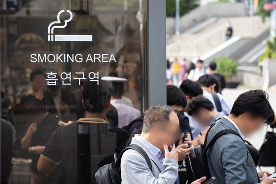 Smokers smoke outside the designated area due to lack of space in downtown Seoul on May 31, 2023. [NEWS1]