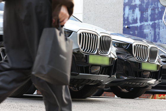 BMW vehicles with light green license plates are parked at a parking lot in Seoul on Sunday. [YONHAP]