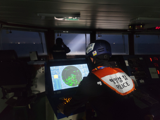 Coast guard officers search for missing crew members aboard the 129-ton Geumseong that sank off Jeju Island the previous day, in this photo provided by the Jeju Coast Guard on Saturday. [YONHAP]