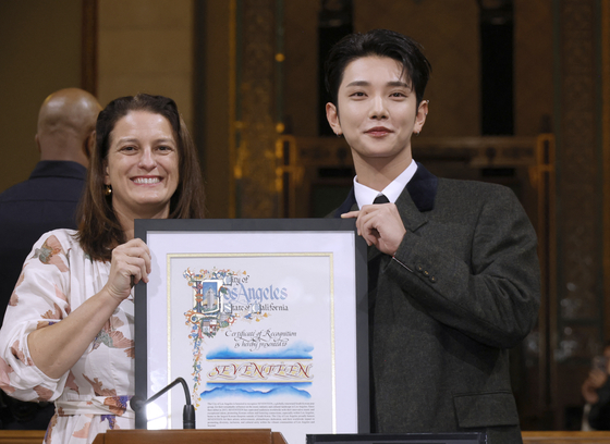 Seventeen group member Joshua, right, accepts on behalf of the band a certificate of recognition from Councilwoman Katy Yaroslavsky honoring the group during the Los Angeles City Council Meeting at Los Angeles City Hall on Friday. [GETTY/YONHAP]