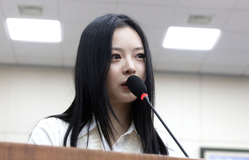 Hanni of girl group NewJeans sheds tears while testifying at the National Assembly's Environment and Labor Committee on Oct. 15 in western Seoul. [JOINT PRESS CORPS]